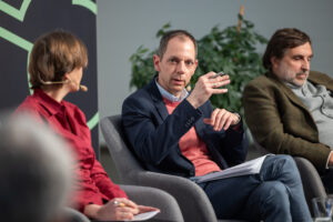 Ein Mann diskutiert mit anderen Teilnehmer*innen.