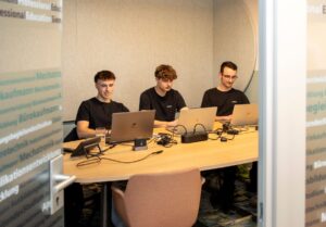 Drei Studierende sitzen am Tisch und lernen.