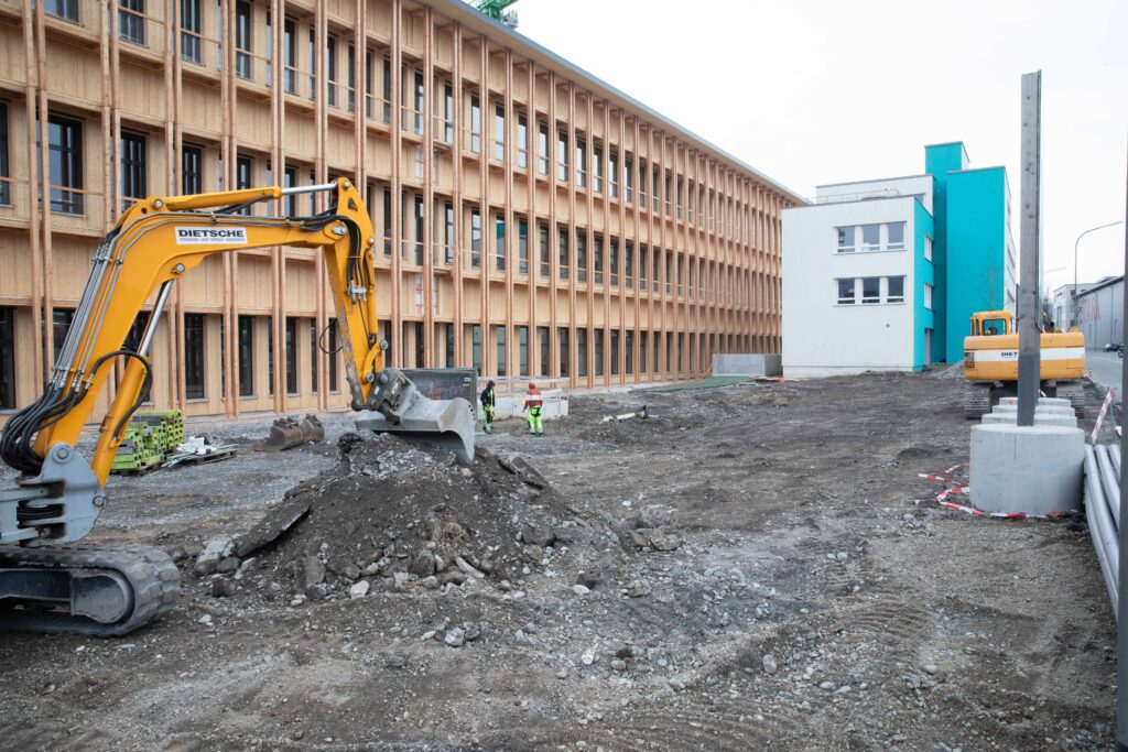 Das aktuelle Bauprojekt des Schweizer Unternehmers Karl Zünd ist ein Industriekomplex mit 100 Meter Seitenlänge und einer Holzfassade. Die Fläche davor wird mit heimischen Baum- und Straucharten bepflanzt. Teilweise wird der kleine Wald mit alten Bäumen bepflanzt, die an anderen Orten gefällt werden würden. © Conrad Amber