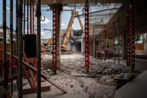  Präzisionsarbeit im Innenbereich: Ein Abbruchbagger entfernt gezielt nicht erhaltungsfähige Bauteile des ehemaligen Postbank-Karrees, während tragende Strukturen für die Integration in The Verse vorbereitet werden.© Leonie Lorenz