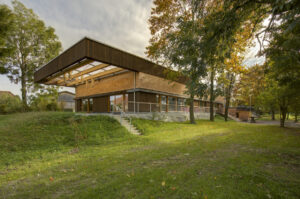 Ein modernes Haus mit überhängendem Dach steht im Grünen.