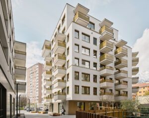 Ein Neubau mit mehreren Stöcken und vielen Balkonen und großen Fenstern.