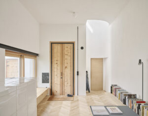 Ein Innenraum in einem hellen, modernen Haus. Das Zimmer ist lichtdurchflutet und hat hohe Decken.