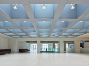 Ein Foyer mit bläulicher Glasdecke und hellem Boden.