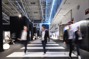 Besucher gehen über einen Indoor-Zebrastreifen.