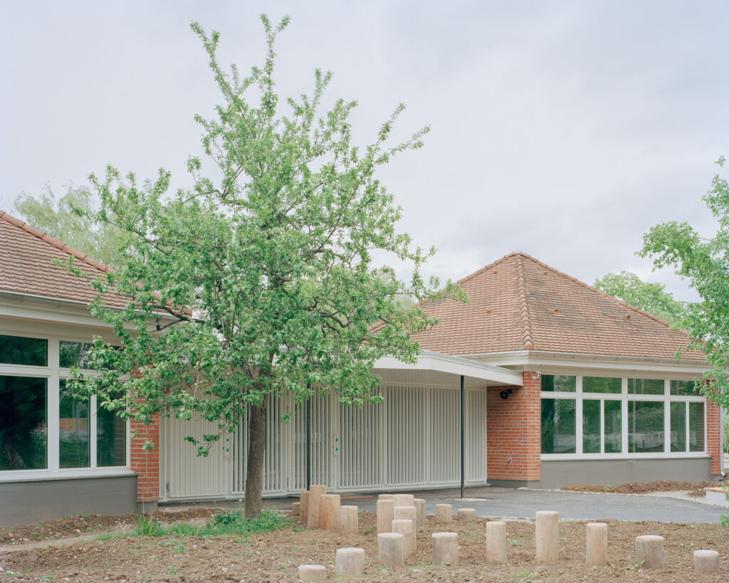 Ein Bungalow bestehend aus zwei ziegelroten Häusern mit Pyramiden-Dächern.