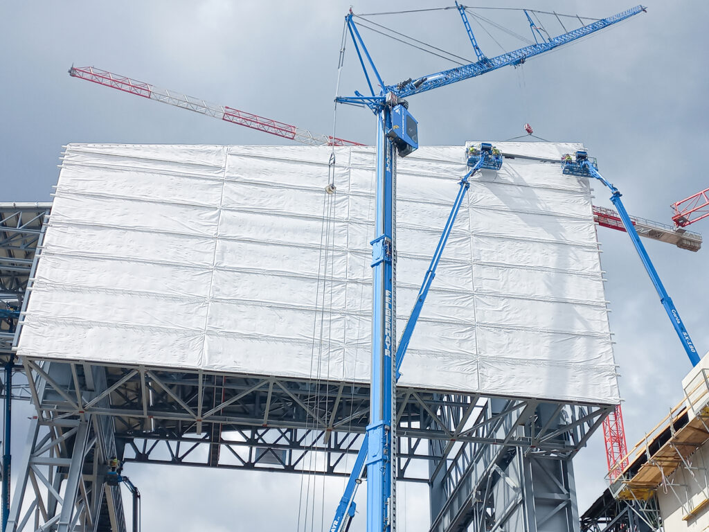 Die Montage der Elemente erfolgt reibungslos – trotz Höhen von bis zu 58 Metern, komplexem Stahlbau und begrenzter Zugänglichkeit. © Domico