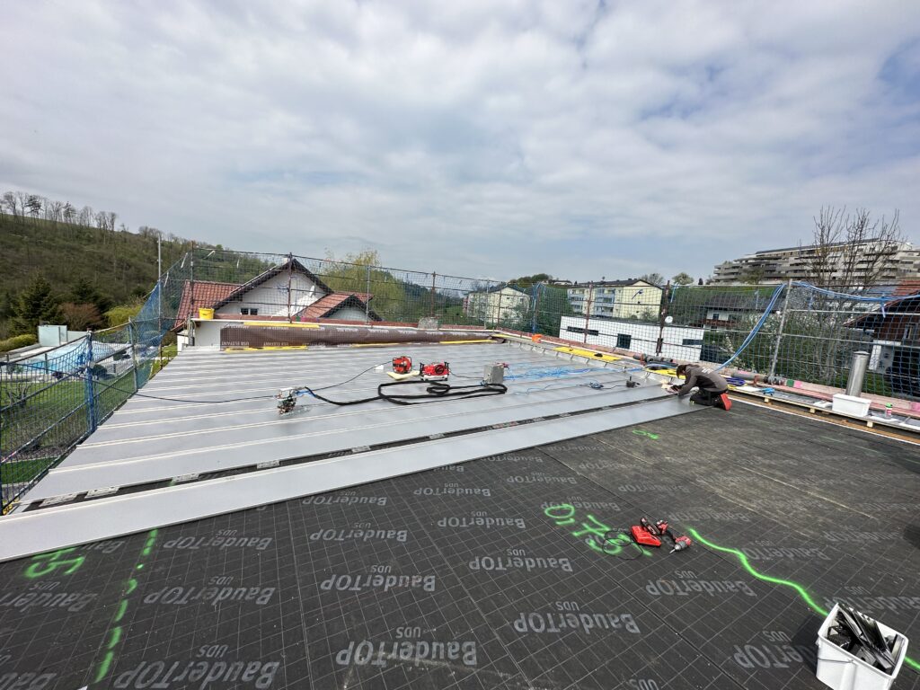 Dachsanierung bei einem Wohnhaus in Gramastetten. Vor dem Befestigen und Verschweißen werden die Profile firstseitig vorbereitet. © Philipp Kastl