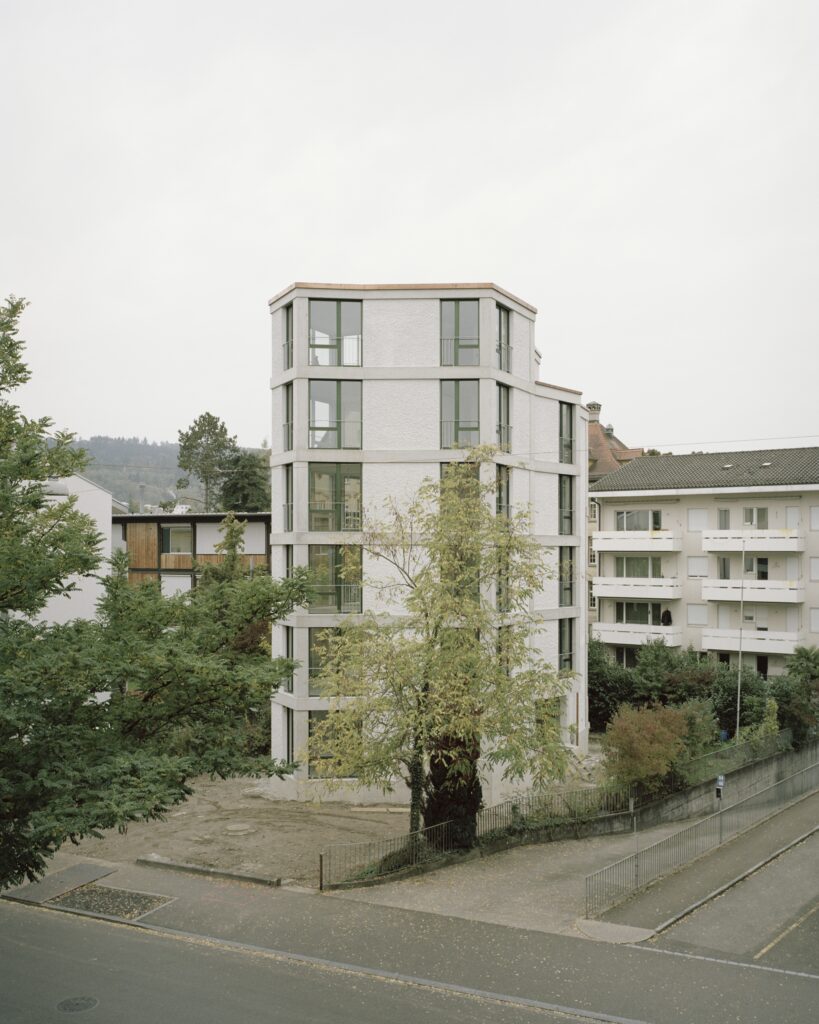 Ein hoher Neubau im Grünen.