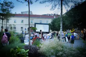 Gäste stehen vor einer Leinwand im Freiluftkino.