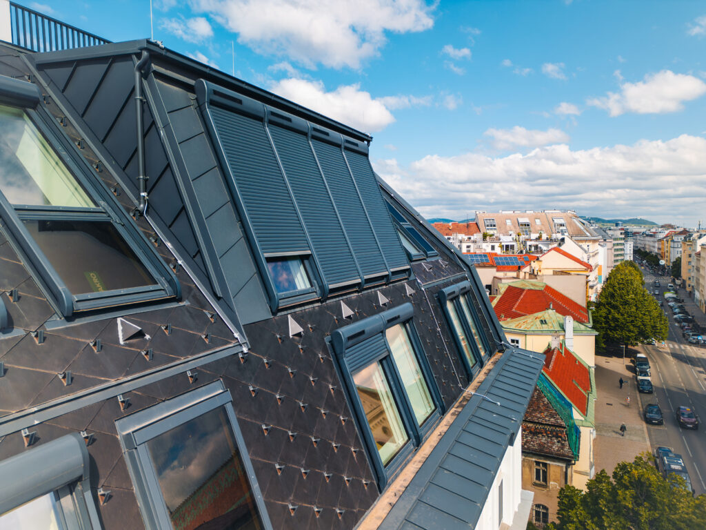 Die außenliegenden und solarbetriebenen Rollläden „ARZ Komfort Solar“ überdecken jeweils zwei übereinanderliegende Dachfenster – elegant und ohne sichtbaren Mittelsteg oder klobige Rollladenkästen. © Fakro