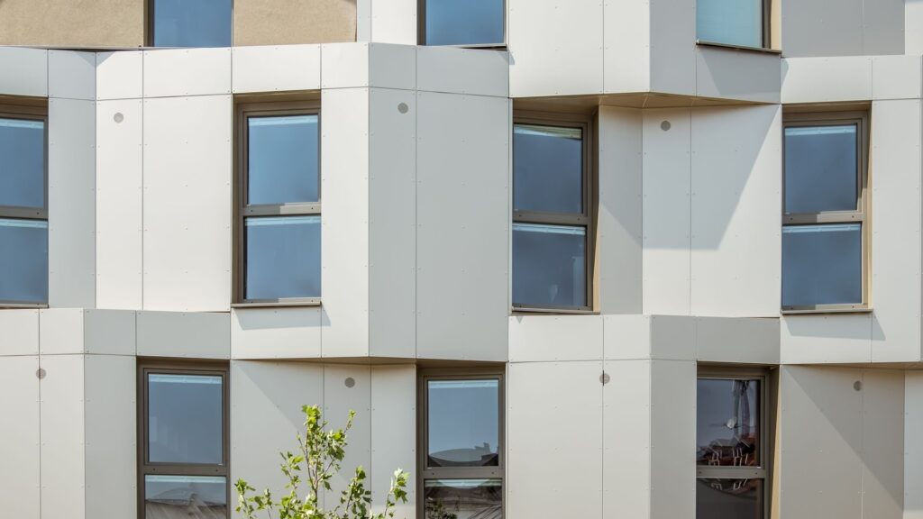 Die bronzefarbenen Metallplatten wurden in bewusst unregel-mäßigem Rhythmus vor- und zurückspringend montiert und lenken den Blick auf die einzelnen Zimmer abwechselnd nach Osten oder Westen.