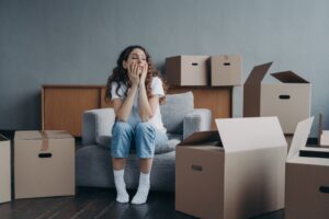 Junge verzweifelte Frau vor Umzugskartons. © Viorel Kurnosov iStock Getty Images Plus