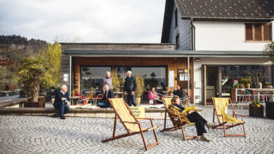 Ein Autofreier Dorfplatz mi Liegestühlen.