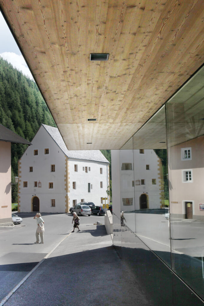 Modernes Glasgebäude mit Holz steht in ruraler Gegend.