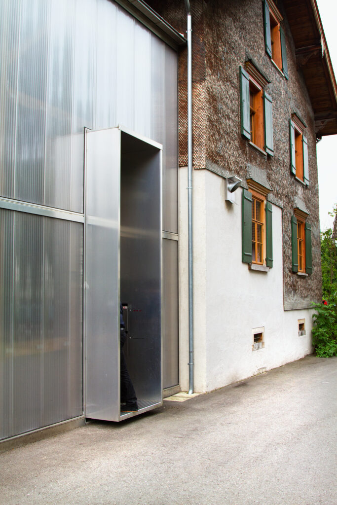 Ein altes Bauernhaus mit metallenen Zubau.
