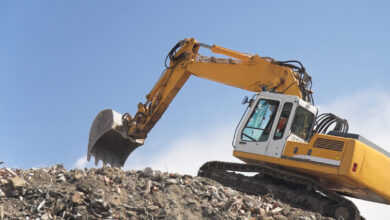 Excavator on a hill of debris