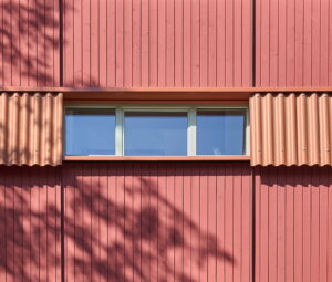 Das Beschichtungswerk lieferte die Fassadenbretter bereits fertig beschichtet mit Keim „Lignosil-Color“ im Farbton Oxydrot Dunkel. Auf der Baustelle wurden nur noch die Stirnflächen nachgestrichen.© Baubild / Stephan Falk